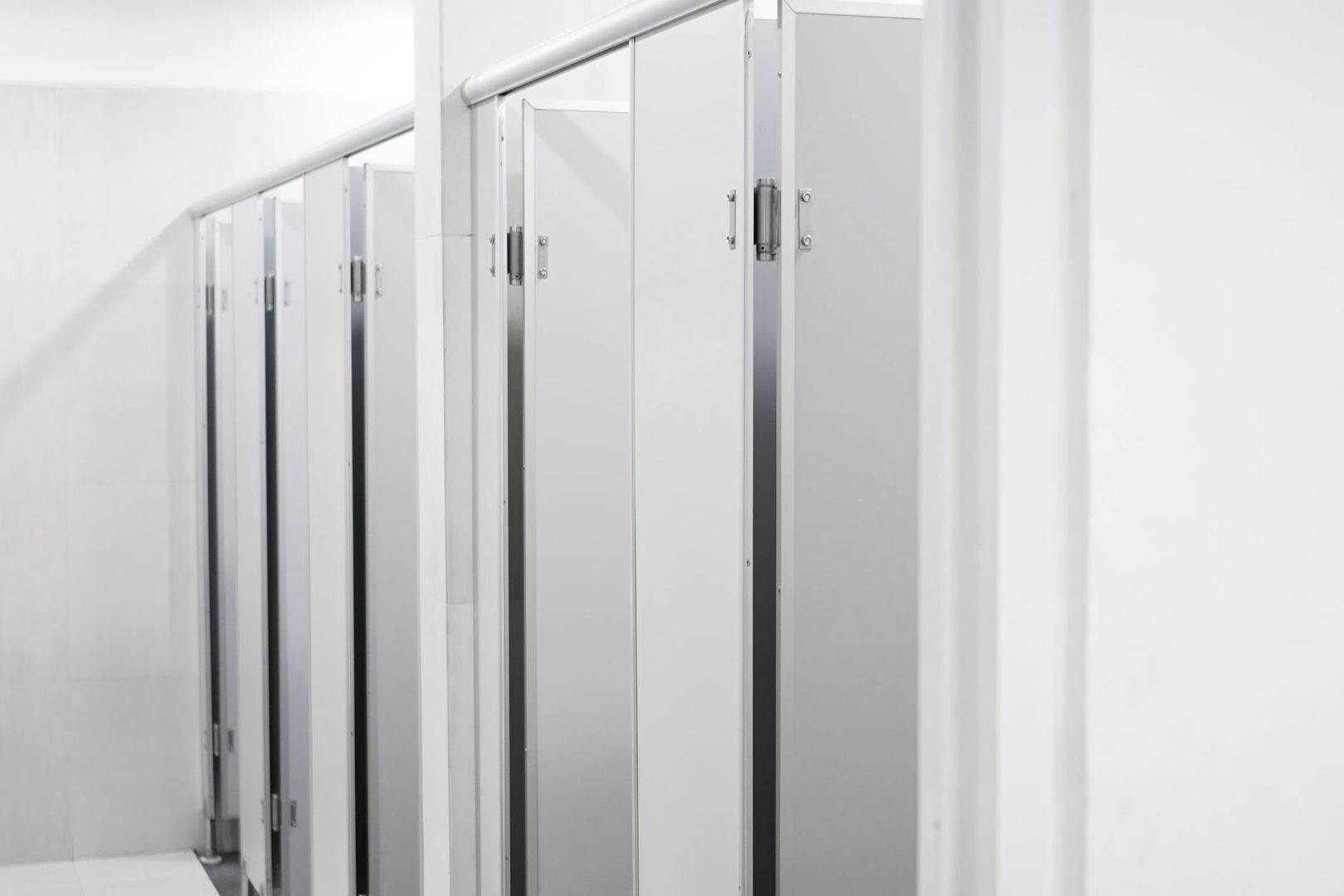 Intérieur moderne de toilettes publiques avec cabines blanches épurées.