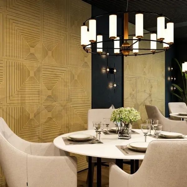 Salle de restaurant élégante avec panneaux muraux texturés et lustre