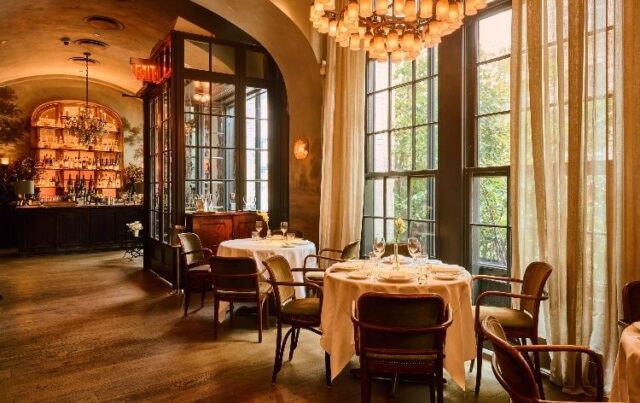 Salle de restaurant élégante, tables dressées et grand bar éclairé